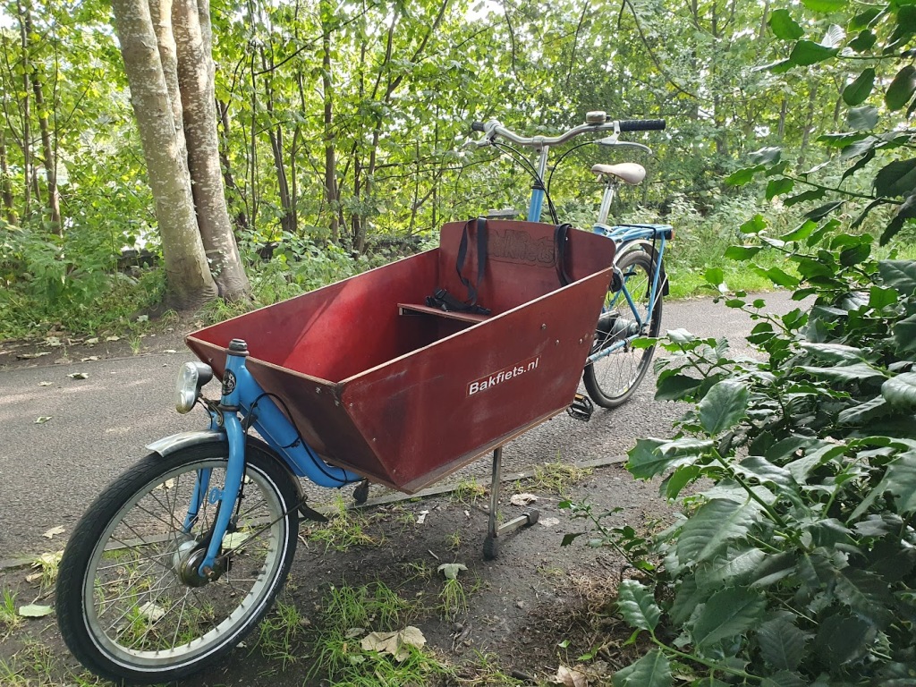 A bakfiets Dutch cargo bike with a long wooden box on the front.
